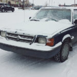 Black car covered with snow in a parking lot