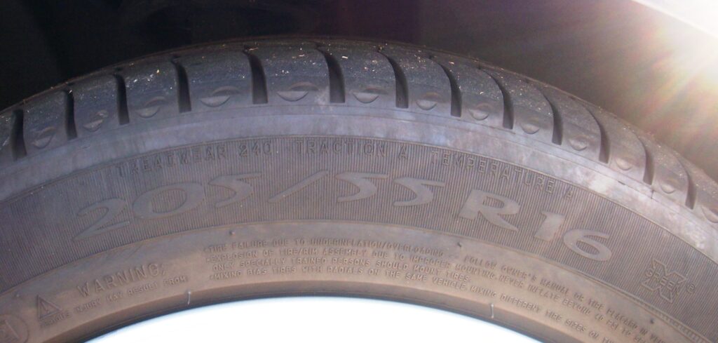 Car tire sidewall showing a 205/55 R16 size marking