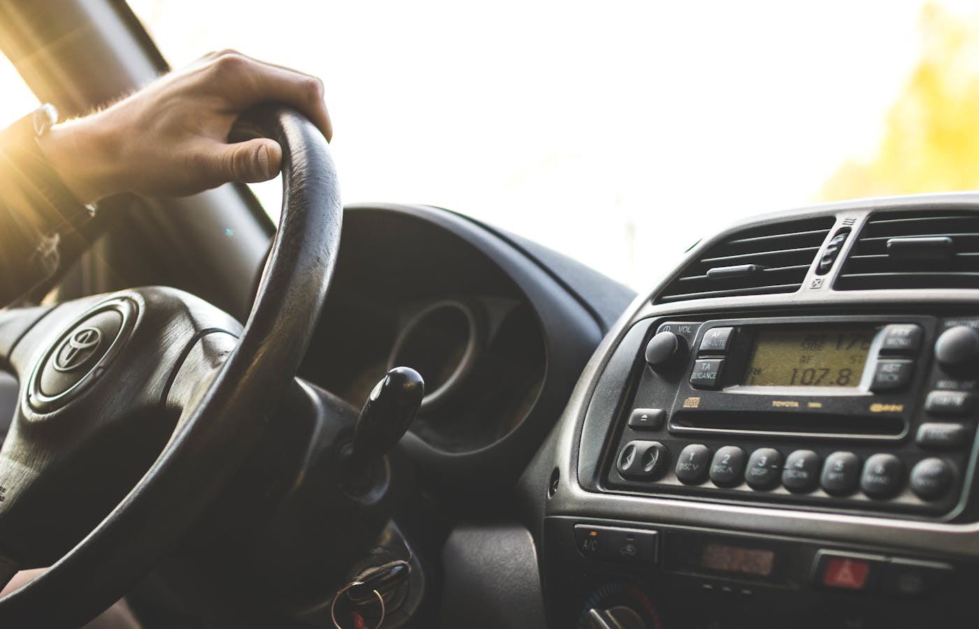 Driver hand on a steering wheel inside a car