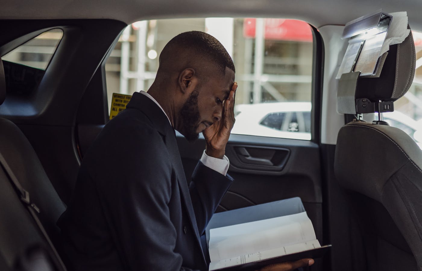 Person reading car documents in the back seat