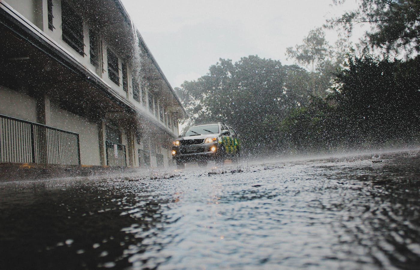 Car driving through heavy rain on a flooded street