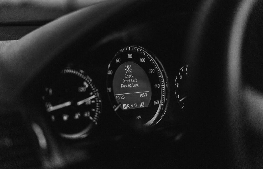 Car dashboard display showing a front left parking lamp warning