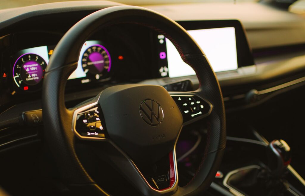 Car dashboard and steering wheel with illuminated screens