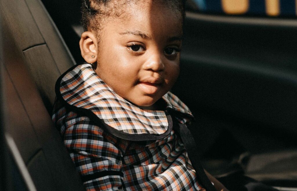 Red seat belt buckle beside a car seat
