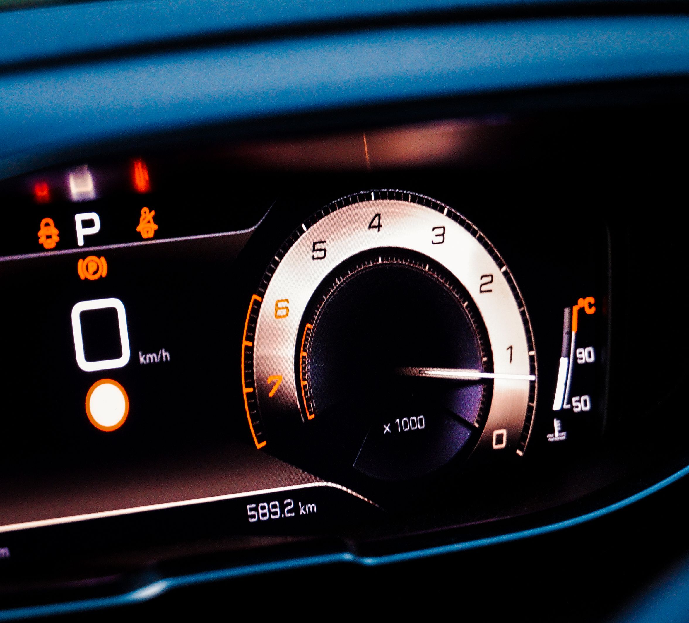 Car dashboard with orange warning icons and a tachometer