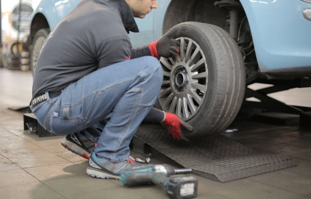 Mechanic holding a car tire in a garage