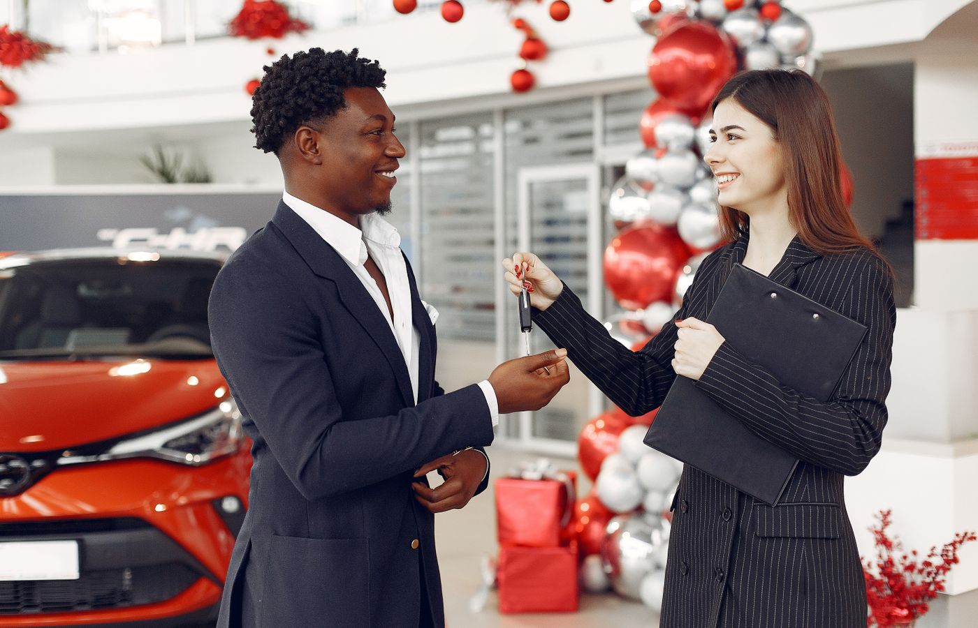 Car keys being handed to a buyer at a dealership