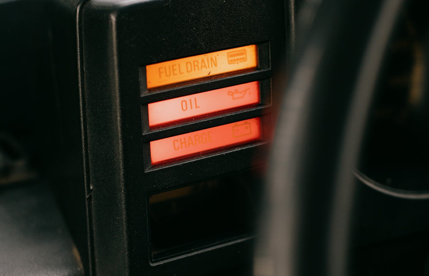 Dashboard charge warning light glowing red in a car