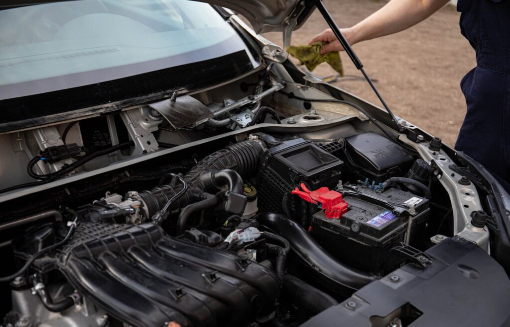 Open car hood with engine bay and battery visible