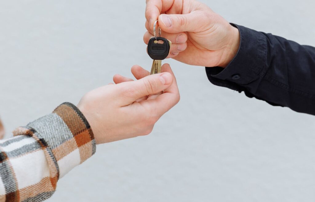 Car key being passed between two hands