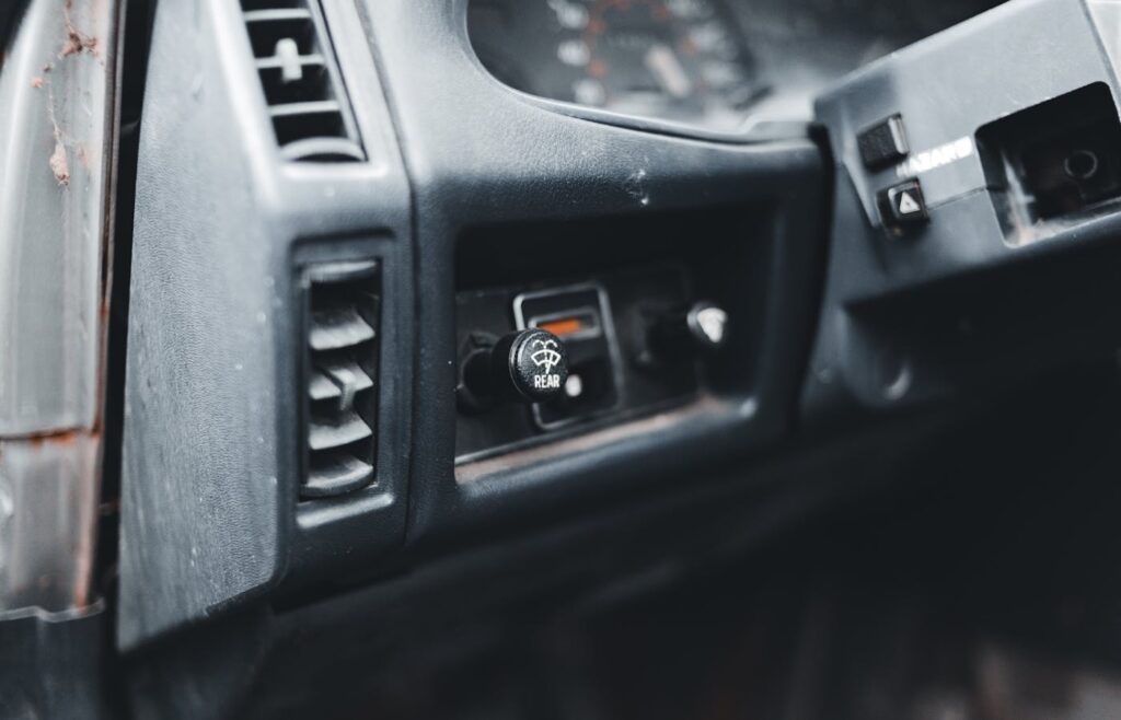 Rear window defroster control on an older car dashboard