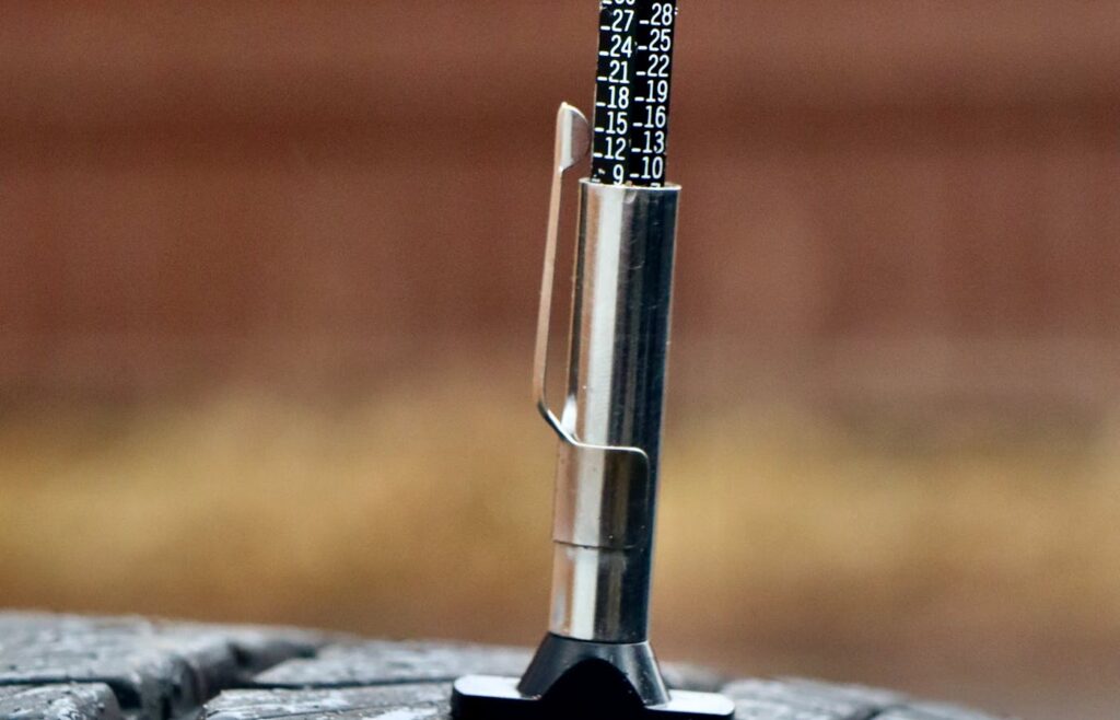 Tire tread depth gauge pressed into a car tire