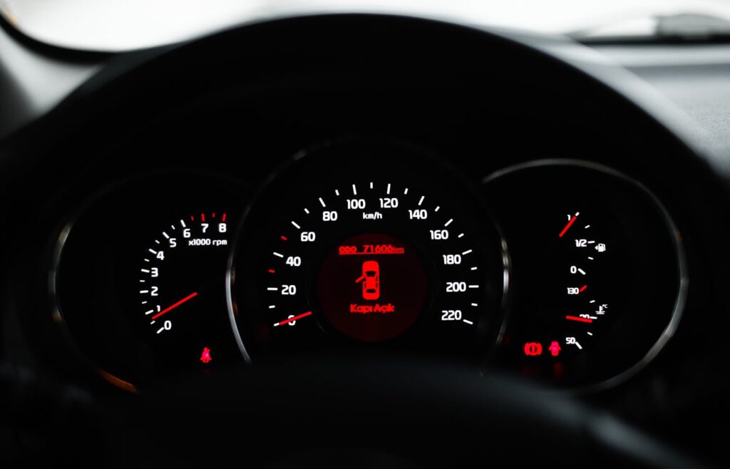 Car dashboard showing red warning icons while parked